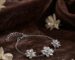 Silver jasmine flower bracelet with three sculpted blossoms on brown velvet