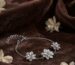 Silver jasmine flower bracelet with three sculpted blossoms on brown velvet