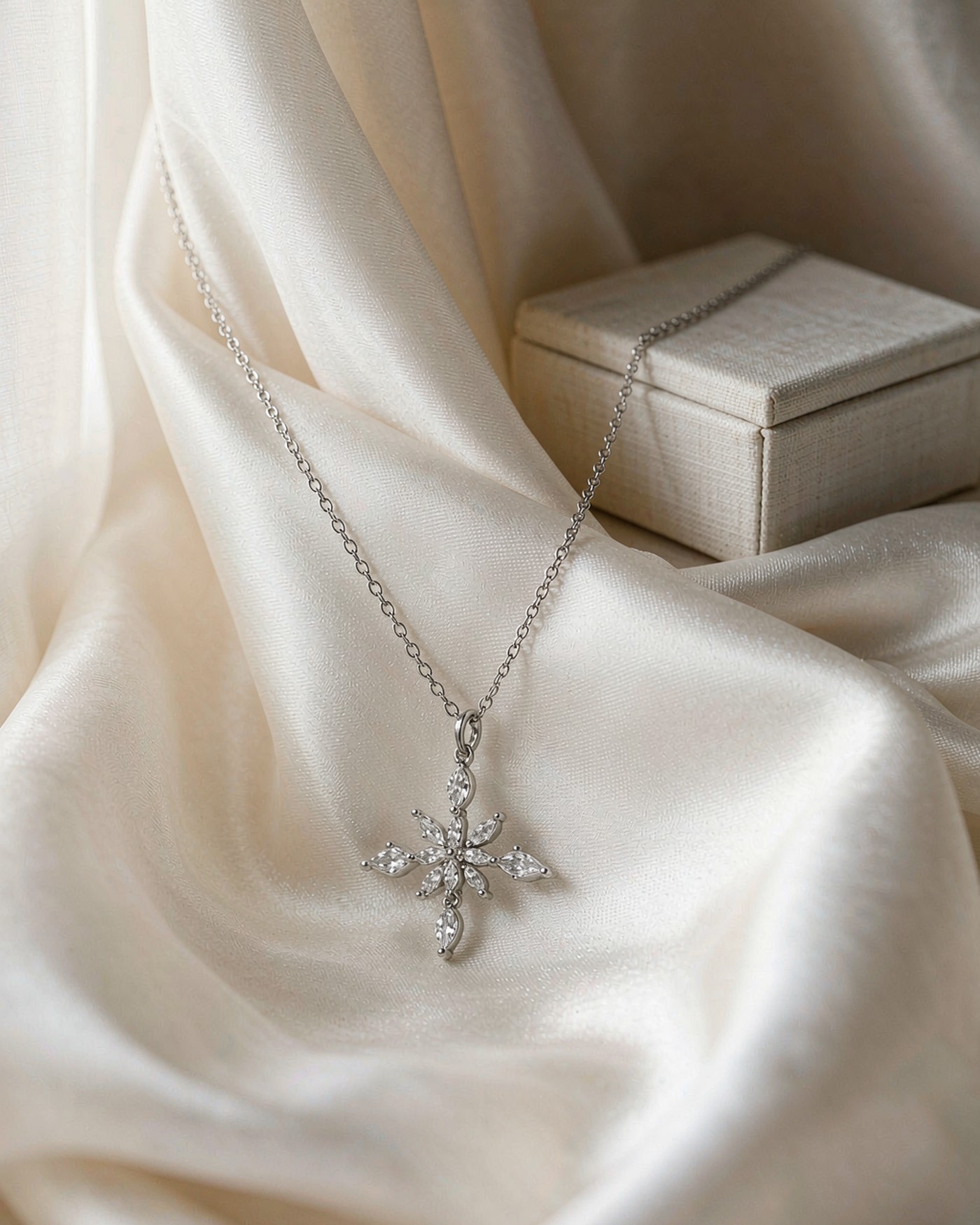 Sterling silver snowflake pendant necklace on ivory silk